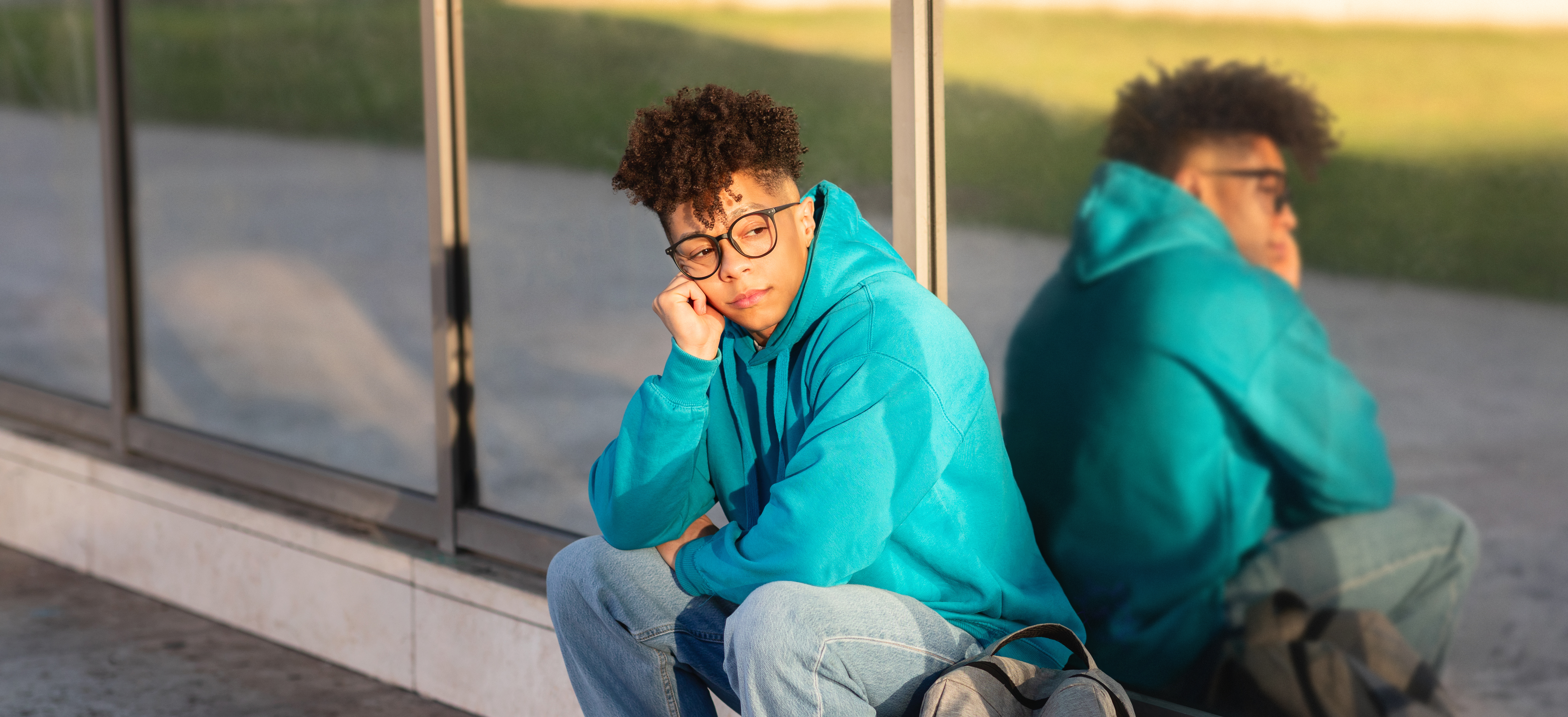 teenager sitting outside with reflection