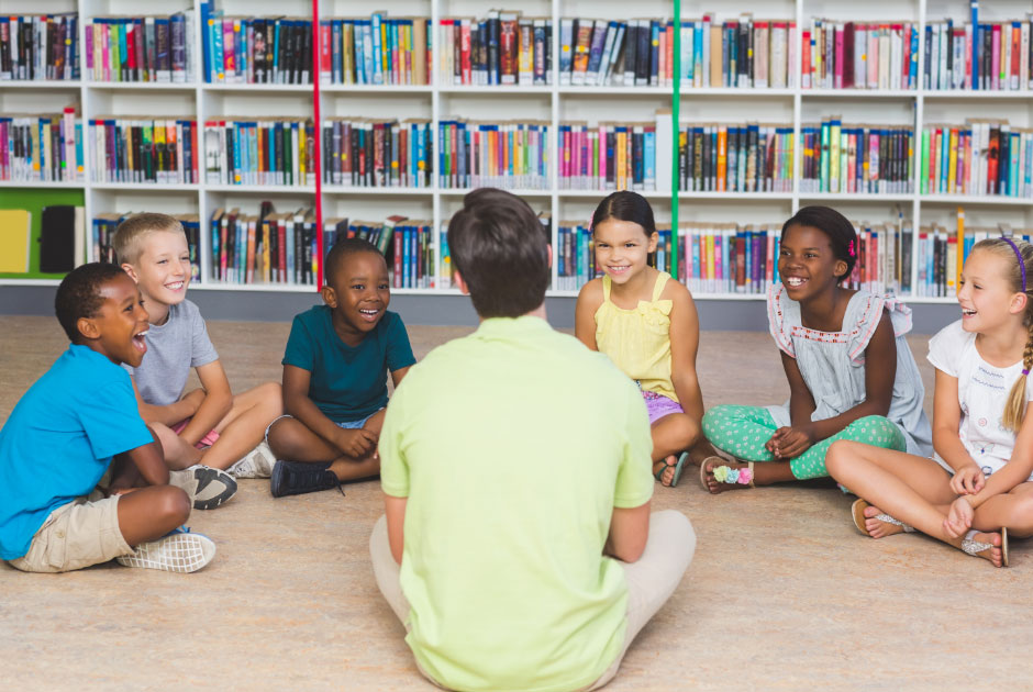 a photo of an adult and children sitting on the floor talking