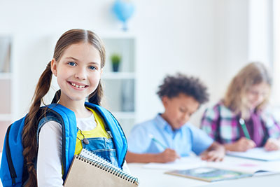 Tween girl looking at camera with other tweens in background