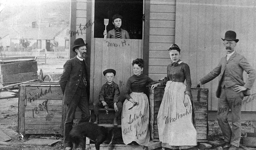 a black and white photo of a familyin front of a building in 1888 in Trinidad