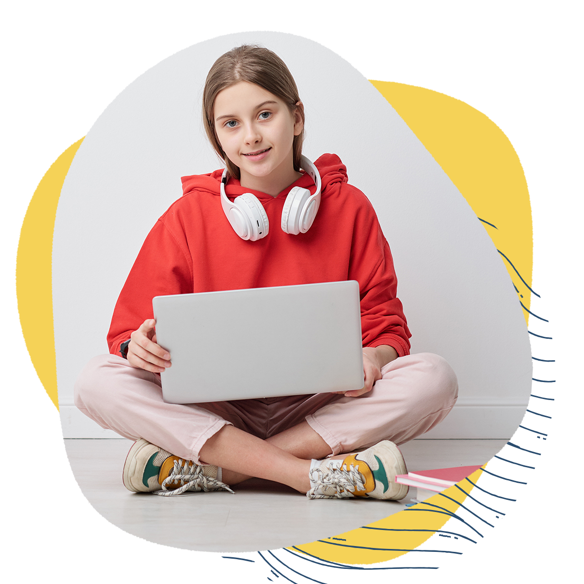 Portrait of high school girl in red hoodie sitting with crossed legs on floor and using portable computer