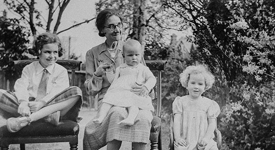 a black and white photo of a mother with three children