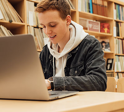 male student working on a laptop in a library