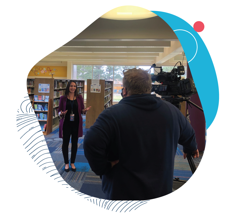 A library Staff member speaking in front of a camera within the Library