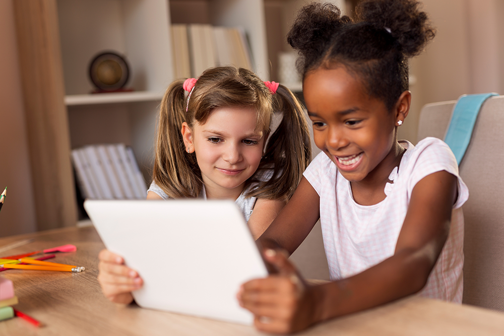 two young girls watching videos on a tablet