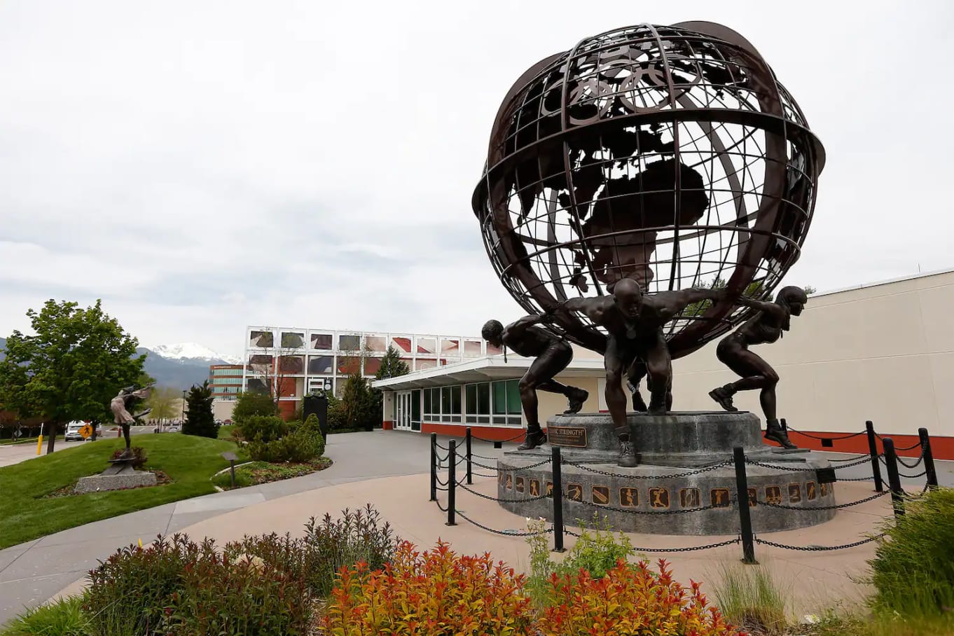 Photo of a statue holding of people holding up a globe in front of the U.S. Olympic & Paralympic Training Center    