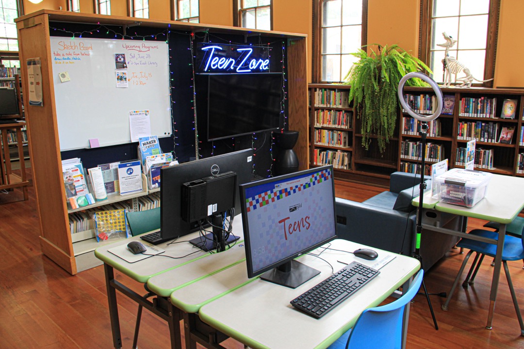 Teen Game Center within Old Colorado City Library, featuring computers and a Neon Sign that says "Teen Zone"