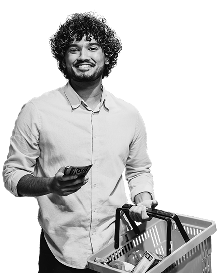 A black and white photo of a Man holding a sell phone and shopping cart