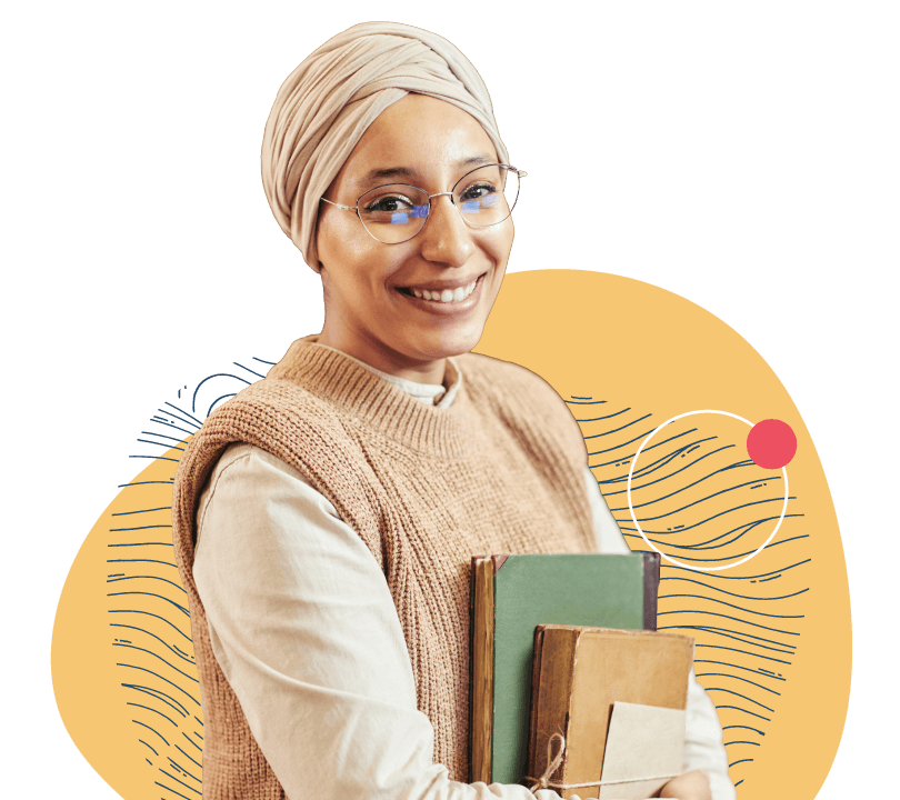 A Librarian smiling with a stack of books in her hand