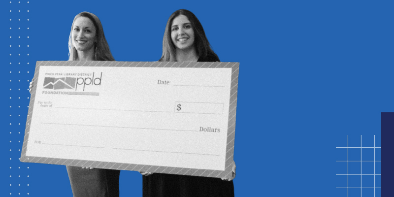 Two staff of the Foundation Library Holding a giant check with the Pikes Peak Library District Foundation Logo
