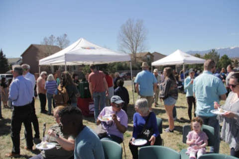 A gathering of people at the purchasing of the new Pony Tracks property for a new Library