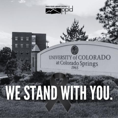 The sign of UCCS in black and white with text that reads "We stand with you."