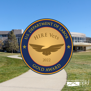 HIRE Vet Medallion Blog A photo of East Library with the HIRE Vets gold medallion in front. The medallion features an abstract eagle.