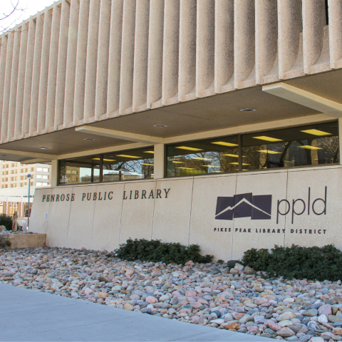 The front of Penrose Library, with the Library District logo displayed on the side of the building.